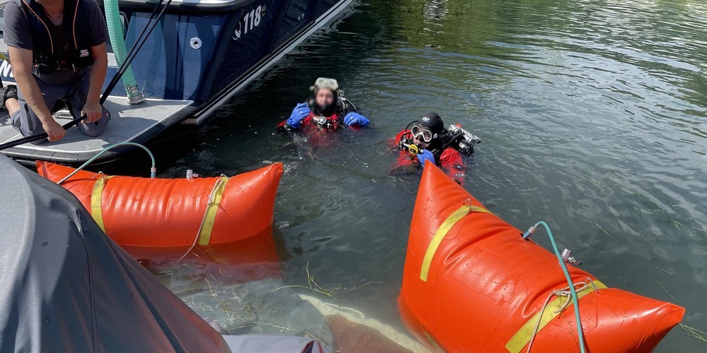 Mitglieder des Seerettungsdiensts bergen das gesunkene Boot. 