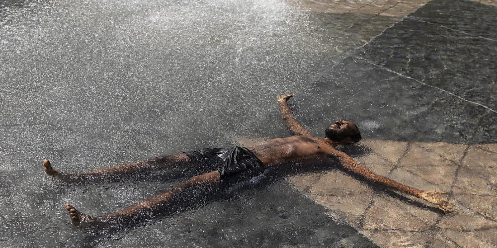 Kais Bothe entspannt und kühlt sich in einem Pool des Rathauses ab. Die anhaltende Hitzewelle im Westen Kanadas hat für neue Höchsttemperaturen gesorgt und zu mehreren Todesfällen beigetragen. Foto: Jason Franson/The Canadian Press/AP/dpa