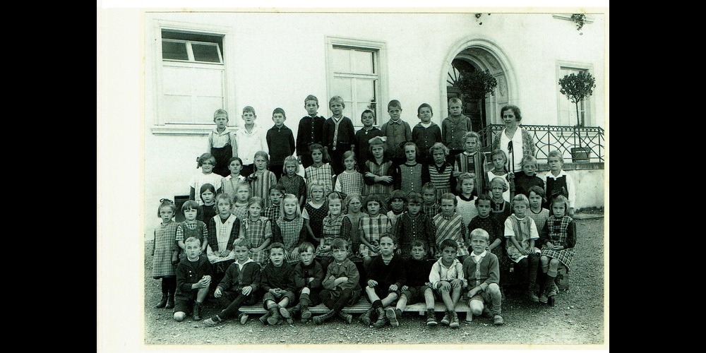 Schulklasse der Lehrerin Anna Pfister, der ersten weiblichen Lehrperson in Grüningen, 1928 vor dem Zentralschulhaus.