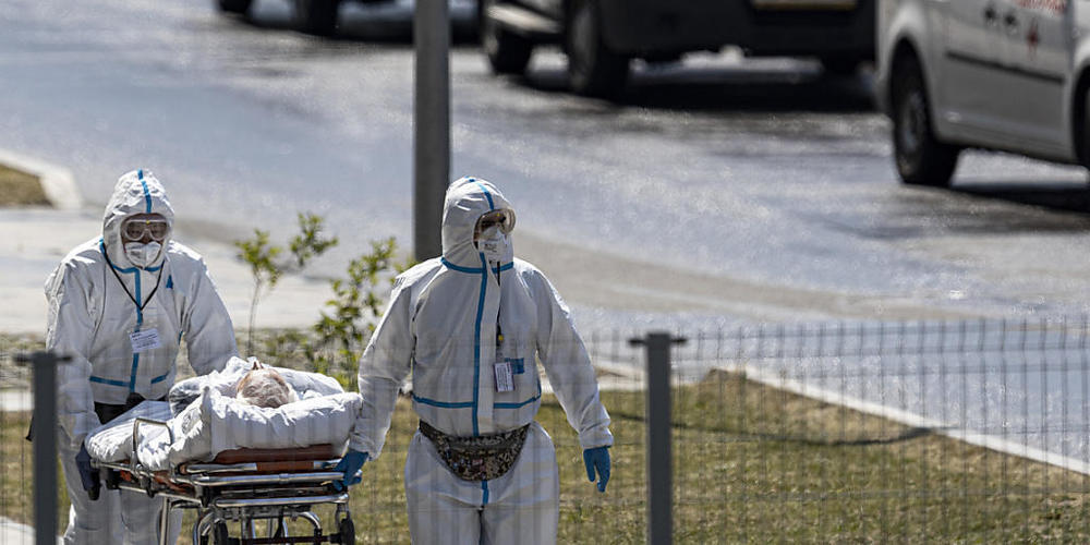 ARCHIV - Medizinisches Personal transportiert einen Patienten mit Corona-Verdacht auf dem Gelände eines Moskauer Krankenhauses. Foto: Alexander Zemlianichenko/AP/dpa