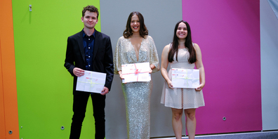 Anna Picard (Mitte, Rang 1), flankiert von Tristan Koning und Fabienne Brunner (Rang 2), bei der Übergabe der Urkunde für die besten Maturaarbeiten 2021.