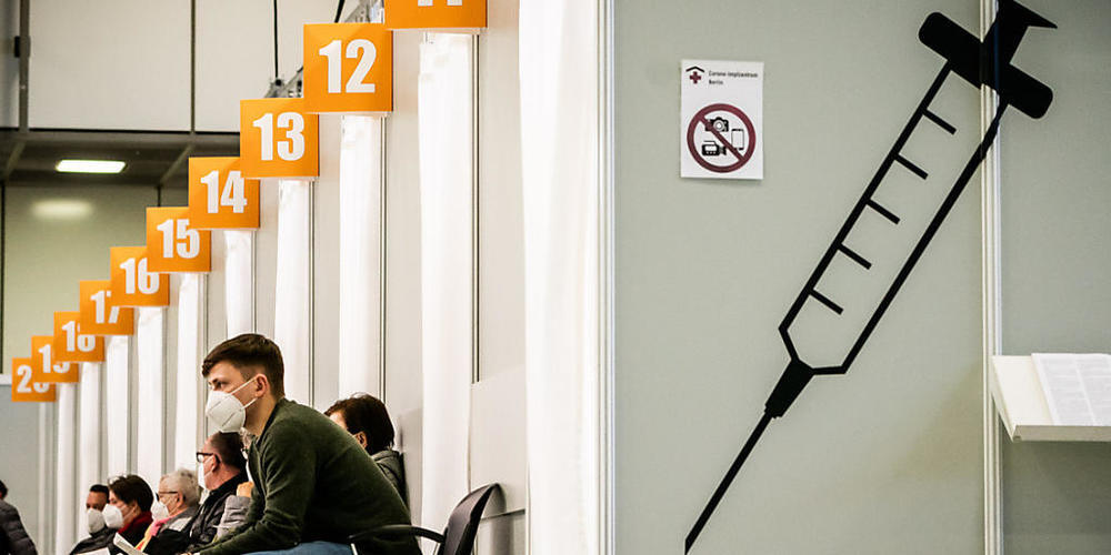 ARCHIV - Menschen warten im Corona-Impfzentrum auf dem Messegelände in Berlin auf ihre Impfung. Foto: Michael Kappeler/dpa
