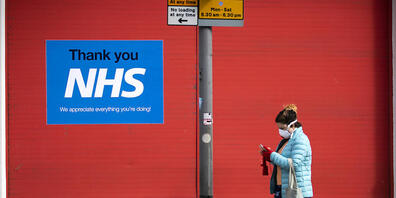 ARCHIV - Eine Frau geht im schottischen Edinburgh an einem Plakat mit der Aufschrift «Thank you NHS» vorbei. Foto: Jane Barlow/PA Wire/dpa