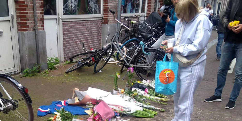 Eine Frau steht vor Blumen am Tatort, nachdem dort am Abend des 6. Juli der niederländische Journalist de Vries niedergeschossen wurde. Foto: Molly Quell/AP/dpa