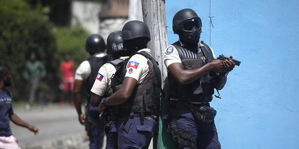 Polizisten mit gezogenen Waffen suchen in Port-au-Prince nach Verdächtigen im Mordfall des haitianischen Präsidenten Jovenel Moise. Foto: Joseph Odelyn/AP/dpa