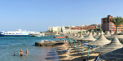 ARCHIV - Touristen stehen im Wasser an einem Hotel-Strand. (Archivbild) Foto: picture alliance / Benno Schwinghammer/dpa