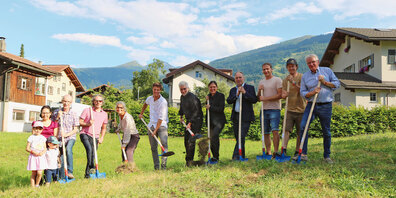 Bauherr Conradin Rüegg (1. v. r.) setzt gemeinsam mit Immobilienunternehmerin Franca Strasser (6. v. l.),  Bauleiter Livio Arpagaus (v. l. n. r.), Architekt Daniel Oes, Architektin Eveline Oes, Gemeindepräsident  Werner Bär, Gemeindevorstand Patric Bebi und drei Käufern die Schaufel zum ersten Spatenstich an. 