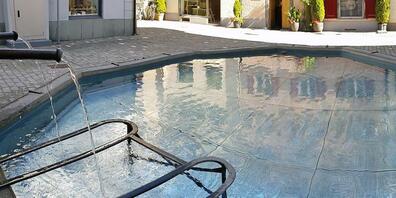 Der Grund des historischen Storchenbrunnens in Chur wurde mit Aluminiumplatten ausgelegt, auf denen Gigers bekanntes "biomechanisches Muster" fein ziseliert ist.