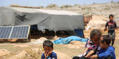 ARCHIV - Geflüchtete Kinder sitzen in einem Flüchtlingslager nordwestlich von Aleppo auf einem Stein. Foto: Juma Mohammad/IMAGESLIVE via ZUMA Wire/dpa