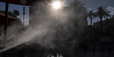 dpatopbilder - Menschen gehen in Las Vegas an Nebelmaschinen vorbei, die zur Abkühlung entlang des Las Vegas Strip eingesetzt werden. Las Vegas könnte an diesem Wochenende sein Temperatur-Allzeithoch erreichen, da für den Bundesstaat und große Tei...
