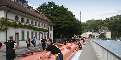 Die Feuerwehr fuellt Wassersperren wegen dem drohenden Hochwasser der Aare im Mattequartier. (KEYSTONE/Peter Klaunzer)