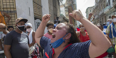 Eine Frau schreit Pro-Regierungs-Parolen, während Anti-Regierungs-Demonstranten in Havanna, Kuba, marschieren. Foto: Ismael Francisco/AP/dpa