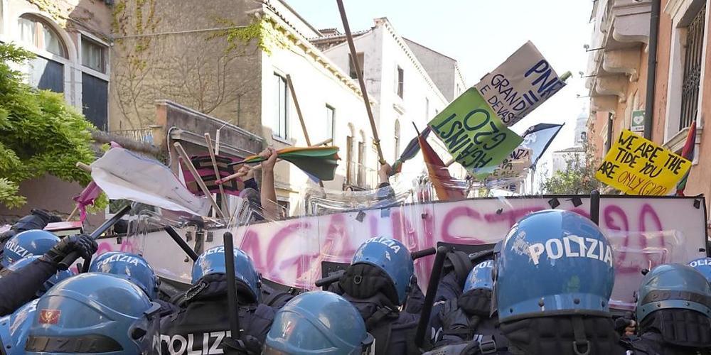Demonstranten gegen den G20-Gipfel der Wirtschafts- und Finanzminister und italienische Polizisten stehen sich gegenüber. Foto: Luca Bruno/AP/dpa