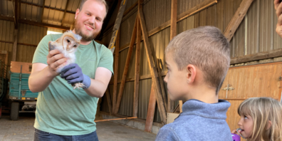 Dominic Frei zeigt den Kindern einen Schleiereulennestling.