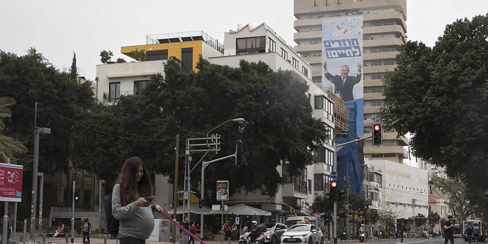 ARCHIV - Eine Passantin geht mit Hunden an einer Gebäudewand in Tel Aviv vorbei. Foto: Sebastian Scheiner/AP/dpa