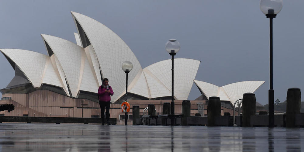 A pedestrian walks past the Sydney Opera House in Sydney, Saturday, July 10, 2021. Tough new restrictions are now in place for Greater Sydney after another spike in COVID-19 cases. (AAP Image/Mick Tsikas) NO ARCHIVING