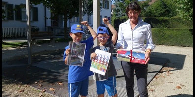 Stadträtin Dorena Raggenbass übergibt den Siegern des Kinderkunstweg-Wettbewerbes, Rafael Wüger und Luca Wüger, ihr Präsent am Signer Brunnen.