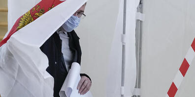 Ein Mann bereitet sich auf die Stimmabgabe in einem Wahllokal in Russland vor. Foto: Pavel Golovkin/AP/dpa