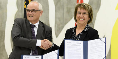 Der Berner Regierungsrat Pierre Alain Schnegg und seine jurassische Amtskollegin Nathalie Barthoulot mit der unterzeichneten Roadmap für Moutier.