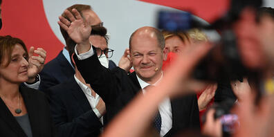 Olaf Scholz, Finanzminister und SPD-Kanzlerkandidat, winkt neben seiner Frau Britta Ernst während der Wahlparty im Willy-Brandt-Haus. Foto: Britta Pedersen/dpa