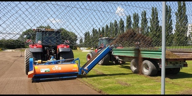 Eine Fräse trägt den bestehenden Rasen ab.