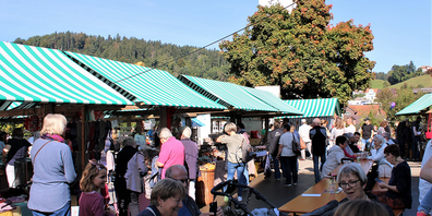 Hochbetrieb auf dem Marktplatz, mit Aussicht auf die herbstliche Natur.