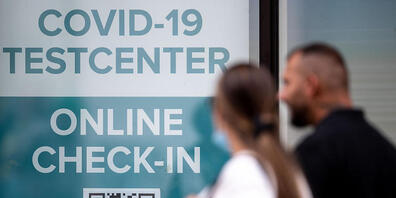 Zwei Menschen gehen an einem Kölner Covid-19 Testcenter vorbei. In Deutschland liegt erstmals seit drei Monaten die Sieben-Tage-Inzidenz der Corona-Neuinfektionen wieder über 50. Nach Angaben des landesweit in der Pandemie federführenden Robert Ko...