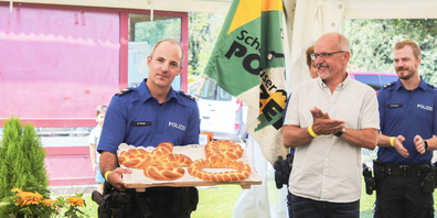 Mario Läubli (Mitte) übergibt Martin Müller (l.), dem Postenchef in Thayngen, bei der Eröffnung den symbolischen Schlüssel und die Handschellen in Zopfform.