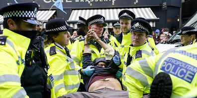 Polizisten verhaften einen Demonstranten, der sich während eines von der Umweltschutzbewegung Extinction Rebellion organisierten Protests unter einen Lieferwagen klebte. Bei der Protestaktion in London laut Mitteilung von Scotland Yard am späten M...
