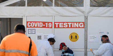 People are seen waiting to receive a Covid test in Lakemba, south west of Sydney, Friday, August 20, 2021. NSW has recorded 642 new local COVID-19 cases and four deaths as the government imposes curfews on Sydney's council areas of concern. (AAP I...