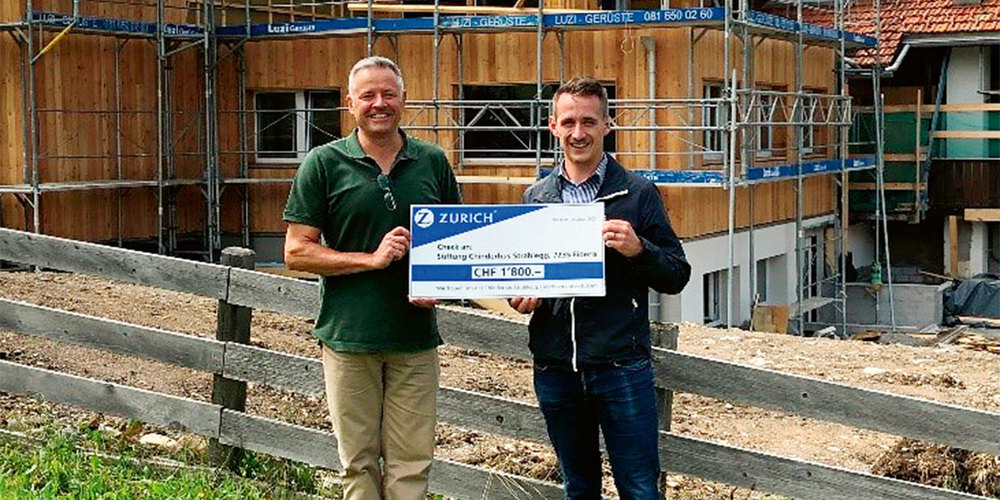 Jürg Egli, Heimleiter des Chinderhus Strahlegg, zusammen mit Pascal Lüthi, Zurich Versicherung in Klosters, bei der Übergabe des Checks auf der Baustelle.