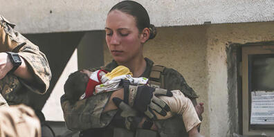 Die Unteroffizierin Nicole Gee vom US Marine Corps beruhigt ein Kleinkind am Flughafen in Kabul. Tage danach stirbt sie bei einem Terroranschag. Foto: Sgt. Isaiah Campbell/U.S. Marine Corps via AP/dpa - ACHTUNG: Nur zur redaktionellen Verwendung u...