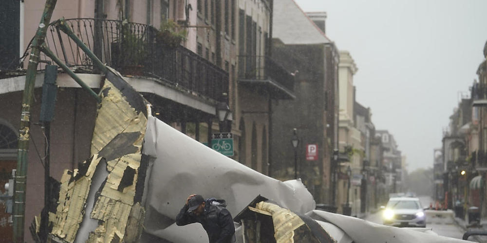 dpatopbilder - Ein Mann geht in New Orleans an einem weggeblasenen Hausdach im French Quarter vorbei. Hurrikan "Ida" hat im südlichen US-Bundesstaat Louisiana ersten Fotos und Videos zufolge massive Schäden verursacht. Foto: Eric Gay/AP/dpa