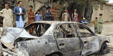 Anwohner betrachten ein durch einen Raketenangriff beschädigtes Fahrzeug. In der afghanischen Hauptstadt Kabul hat es einem Medienbericht zufolge einen Raketenangriff gegeben. Foto: Khwaja Tawfiq Sediqi/AP/dpa