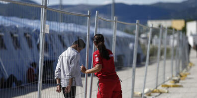 Ein geflüchteter Afghane geht an einem Zaun in einem Einsatzzentrum des italienischen Roten Kreuzes, Croce Rossa Italiana (CRI) in Avezzano. In dem Einsatzzentrum werden mit Hilfe der Armee und des Zivilschutzes afghanische Geflüchtete aufgenommen...