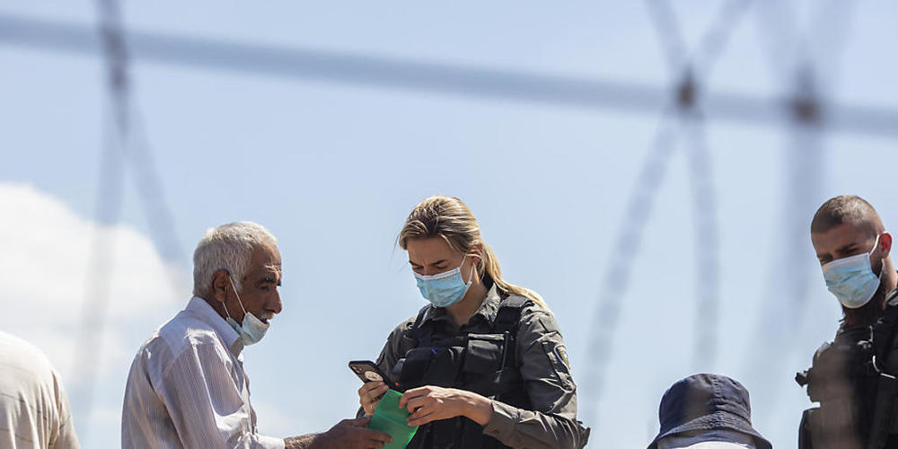 Israelische Soldaten durchsuchen palästinensische Arbeiter, bevor sie ihnen erlauben, einen Sicherheitszaun in der Westjordanlandstadt Dschenin zu überqueren, nachdem sechs palästinensische Gefangene aus dem Gilboa-Gefängnis ausgebrochen sind. Fot...