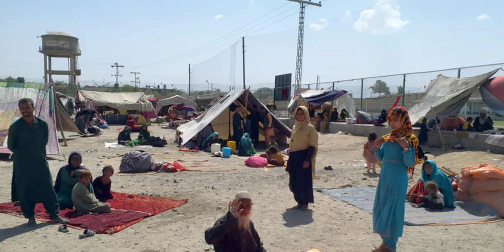 Afghanische Familien sitzen vor ihren Zelten am Rande von Chaman, einer Grenzstadt in der südwestlichen pakistanischen Provinz Belutschistan. Foto: Jafar Khan/AP/dpa