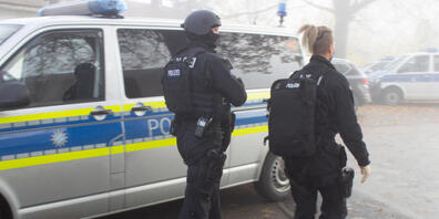 Zwei Polizisten gehen über einen Vorplatz am Bahnhof. Foto: vifogra/dpa