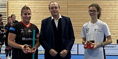 Der Gemeindepräsident von Gossau ZH, Jörg Kündig, ehrt die Bestplayerinnen Rahel Wild (Red Devils) und Simea Monhart (UCCevi Gossau).