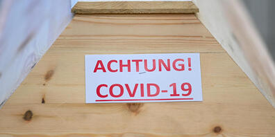  Ein Sarg mit der Aufschrift «Achtung! Covid-19» steht in einem Raum im Krematorium, bevor der Sarg eingeäschert wird. 