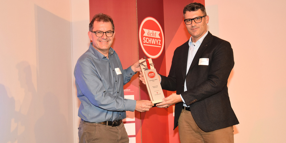 Arno Solèr, der Präsident der Schwyz Tourismus AG, überreicht Andreas Meyerhans (links) den Tourismus-Award «ächt Schwyz».