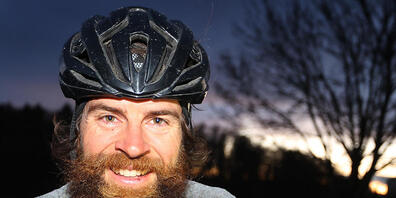 Extrem-Sportler Jonas Deichmann steht nach seiner Grenzüberfahrt aus der Schweiz mit seinem Fahrrad auf einem Feldweg. Nach seinem Triathlon um die Welt kam Deichmann in Baden-Württemberg an. Foto: Karl-Josef Hildenbrand/dpa