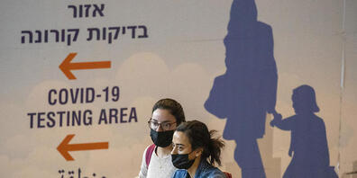 Reisende sind am Ben-Gurion-Flughafen in Tel Aviv unterwegs. Um die Verbreitung der neuen Omikron-Variante des Coronavirus einzudämmen, führt Israel die umstrittene Handy-Überwachung von Corona-Patienten und deren Kontakten wieder ein. Foto: Ariel...