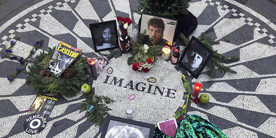 ARCHIV - Fotos, Blumen und Kerzen stehen auf der Gedenkstätte Strawberry Fields im Central Park zur Erinnerung an John Lennon. Vor 50 Jahren veröffentlichte John Lennon seinen Song «Imagine». Das Lied gilt bis heute als hoffnungsvolle Hymne für de...
