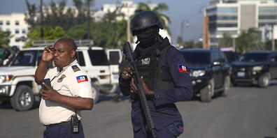 Bewaffnete Sicherheitskräfte stehen auf einer Straße in Port-Au-Prince. Foto: Joseph Odelyn/AP/dpa