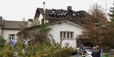 Polizisten vor dem vom tödlichen Brand betroffenen Wohnhaus in Leuzigen BE.