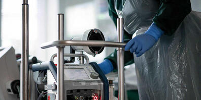 ARCHIV - Eine Mitarbeiterin der Pflege steht in einem Zimmer der Corona-Intensivstation des Universitätsklinikums Essen und bedient ein ECMO-Gerät, eine Herz-Lungen-Maschine. Foto: Fabian Strauch/dpa