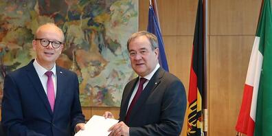 HANDOUT - Armin Laschet (CDU) hat am Montagmorgen sein Amt als nordrhein-westfälischer Ministerpräsident niedergelegt. Landtagspräsident André Kuper (l), überreicht ihm die Urkunde über die Beendigung des Amtes. Foto: Bernd Schälte/Landtag NRW/dpa...