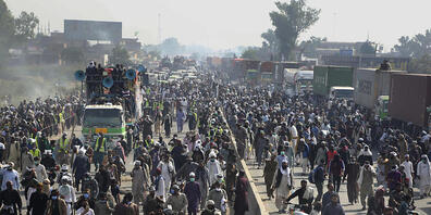 Anhänger der radikal-islamistischen Partei Tehreek-e Labbaik Pakistan (TLP) nehmen an einem Protestmarsch in Richtung Islamabad auf einer Landstraße teil. Foto: K.M. Chaudary/AP/dpa
