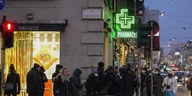 Menschen stehen vor einer Apotheke vor dem Mailänder Dom für Corona-Tests an. Foto: Luca Bruno/AP/dpa